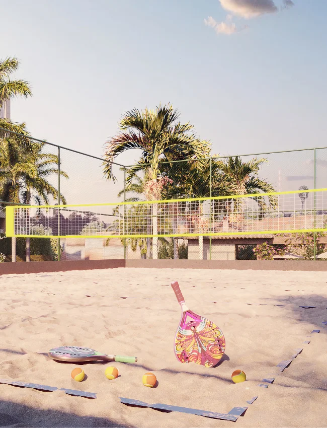 Quadra de beach tennis com areia, rede, bola e duas raquetes coloridas, ideal para diversão ao ar livre e exercício físico.