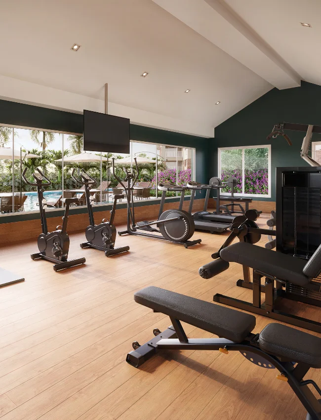 Academia com vista panorâmica da piscina através do vidro. Equipada com bike, esteira e leg press para um treino completo.